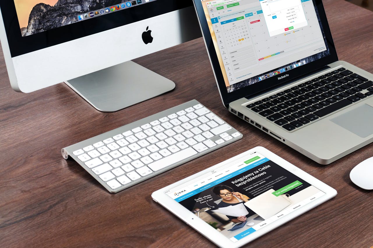 About A sleek office desk setup featuring Apple devices: iMac, MacBook, and iPad.